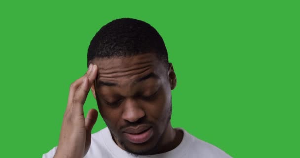 Человек, страдающий от сильной головной боли на зеленом фоне — стоковое видео