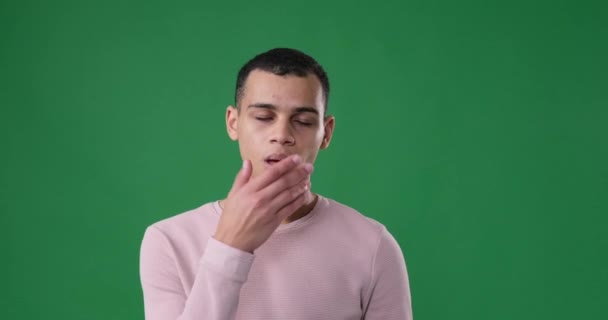 Schläfriger Mann gähnt vor grünem Hintergrund — Stockvideo