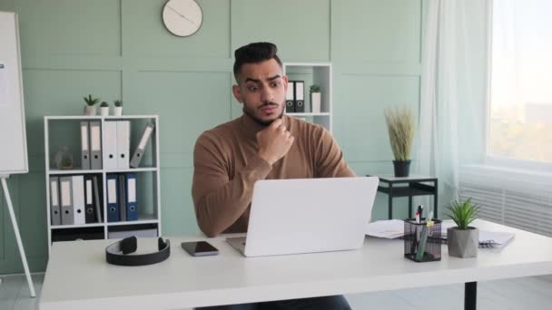 Giovane uomo d'affari venire con una soluzione mentre si lavora sul computer portatile — Video Stock