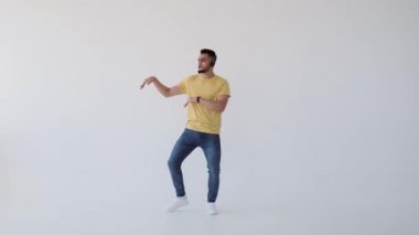 Genç adam kulaklıkla müzik dinlerken dans ediyor.