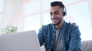 İş adamı müzik dinliyor ve dizüstü bilgisayarda çalışırken eğleniyor.
