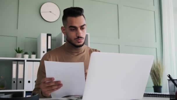 Бізнесмен аналізує документ під час роботи на ноутбуці — стокове відео