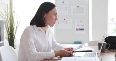 İş kadını video konferansı ofiste dizüstü bilgisayarla yapılıyor