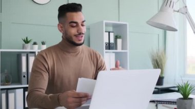 Genç işadamı video konferansı için dizüstü bilgisayar kullanıyor