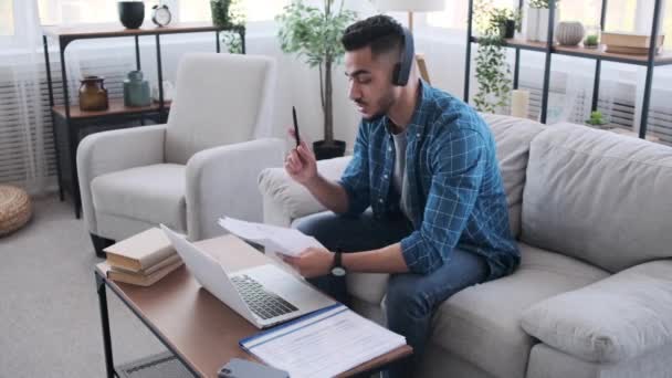 Бізнесмен читає документ під час проведення відеоконференції на ноутбуці — стокове відео