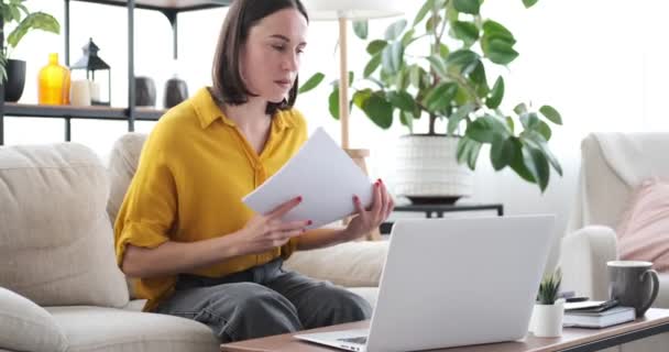 노트북을 사용하고 집에서 서류 작업을 하는 여자 — 비디오