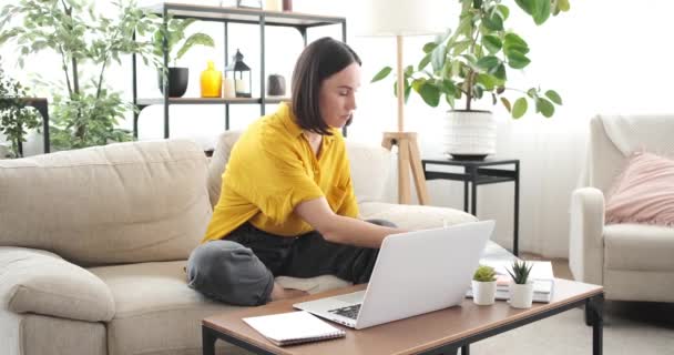 Жінка використовує ноутбук і робить документи вдома — стокове відео
