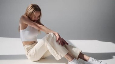 Güzel, genç bir kadın şık kıyafetler içinde poz veriyor.