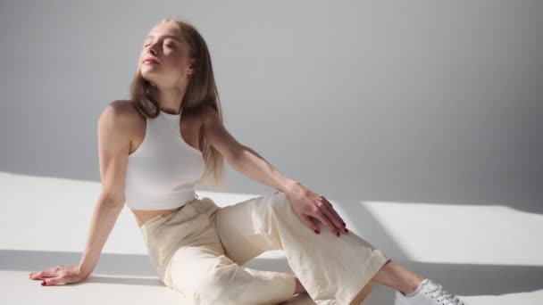 Чувственная женщина позирует, сидя на полу с закрытыми глазами — стоковое видео