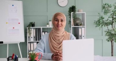 Elleri sımsıkı bağlı gülümseyen Arap iş kadını
