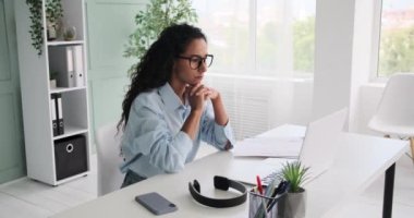 Dizüstü bilgisayarda çalışan ve belgeleri analiz eden genç iş kadını