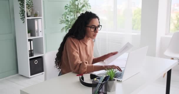 Mujer de negocios escribiendo en el ordenador portátil y el análisis de documentos — Vídeos de Stock