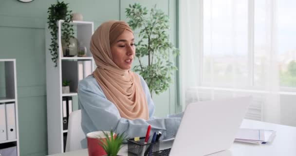 Молода арабська бізнесменка читає документ під час відеоконференції. — стокове відео