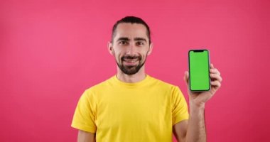 Man pointing finger at mobile phone with green screen