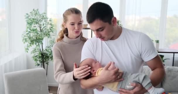 Loving parents with baby boy sleeping in arms of father — Stock video