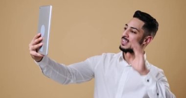 Young businessman video chatting on digital tablet