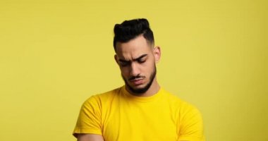 Disappointed man in thoughts over yellow background