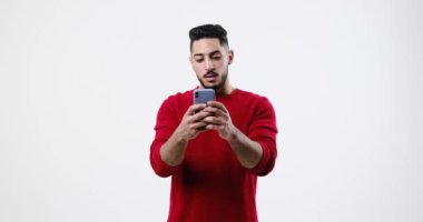 Young man shaking head while using mobile phone
