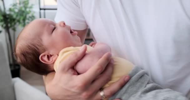 Baby boy yawning while sleeping in arms of father — Stok video