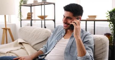 Genç adam cep telefonuyla konuşuyor.