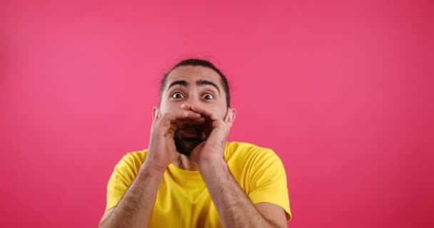 Man whispering secret over pink background — Vídeos de Stock