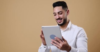 Young businessman having fun while using digital tablet