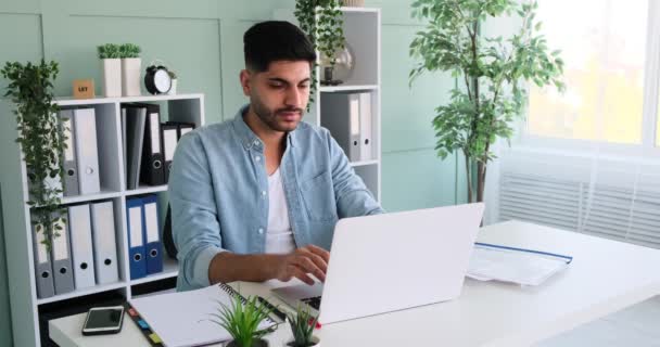 Geschäftsmann arbeitet am Laptop und analysiert Dokumente — Stockvideo