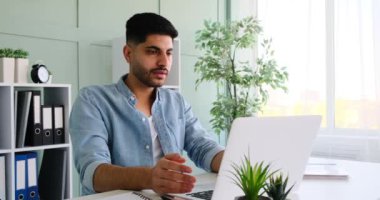 Frustrated young businessman closing laptop