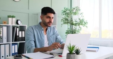 Happy businessman working on laptop and analyzing document