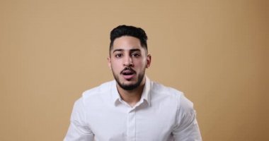 Confused businessman shaking head over beige