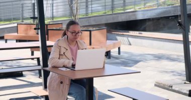 Businesswoman using laptop at cafe