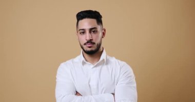 Serious young businessman smiling with arms crossed