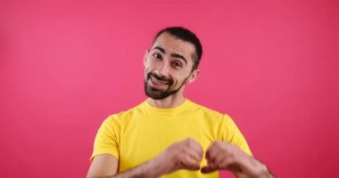 Romantik adam elleriyle aşk işareti yapıyor.