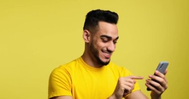 Cheerful man text messaging using mobile phone