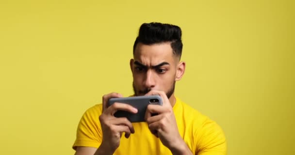 Man playing game on mobile phone and celebrating victory — Stok video