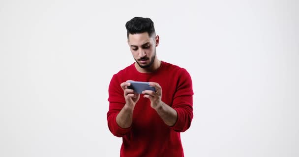 Hombre joven jugando en el teléfono móvil — Vídeos de Stock