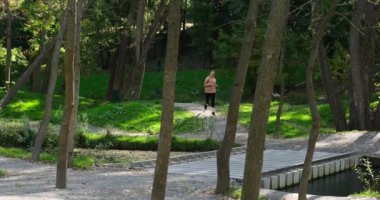 Woman jogging over bridge in forest