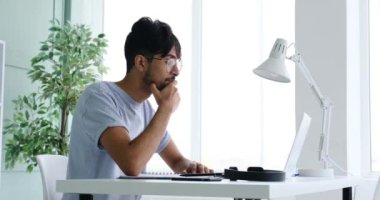 Businessman writing notes while having a video call using laptop