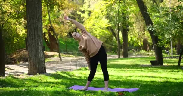 Mujer joven haciendo estiramiento y ejercicio de calentamiento al aire libre — Vídeos de Stock