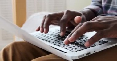Hands typing on laptop at home