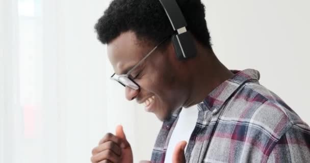 Щасливий чоловік танцює, слухаючи музику на навушниках — стокове відео