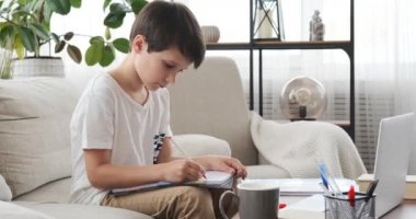 Boy doing homework and having a drink