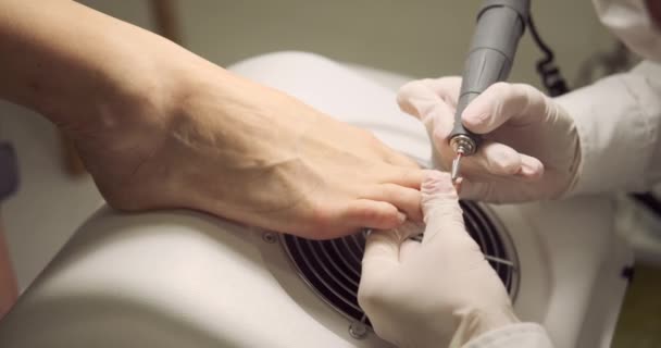 Pedicurist using milling cutter for pedicure service of foot finger nails — Stok video