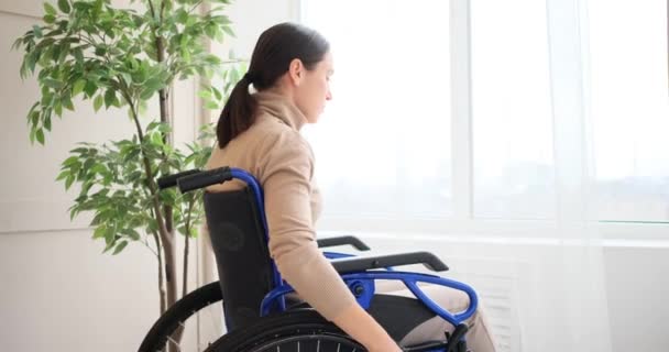 轮椅上残疾妇女从窗户往外看 — 图库视频影像