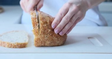 Woman cutting bread with knife