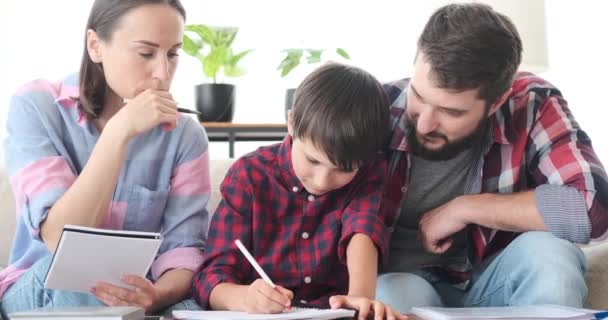 Föräldrar med son som gör läxor hemma — Stockvideo