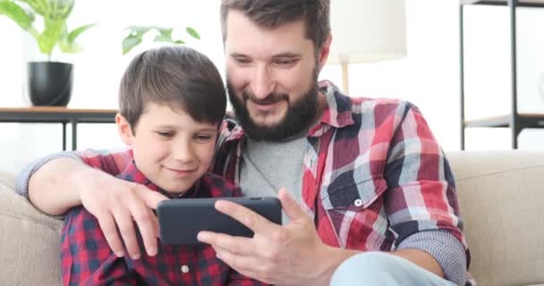 Pai e filho usando telefone celular em casa — Vídeo de Stock