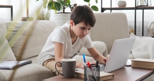 Niño cansado bostezando mientras aprende en línea en el ordenador portátil en casa — Vídeos de Stock