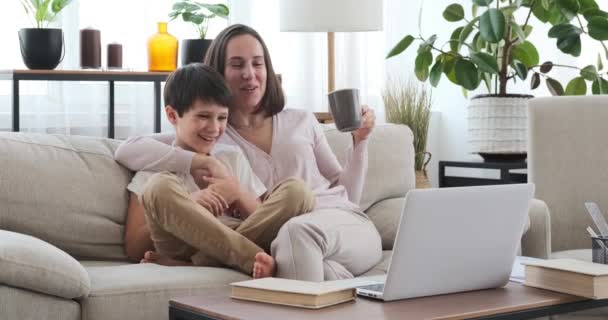 Мать и сын наслаждаются смешным фильмом на ноутбуке — стоковое видео