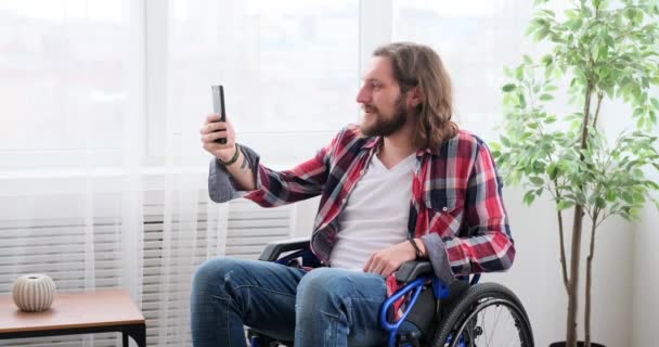 Disabled man video chatting using mobile phone — Vídeo de Stock